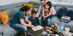Family sits together on couch with their emergency kit materials